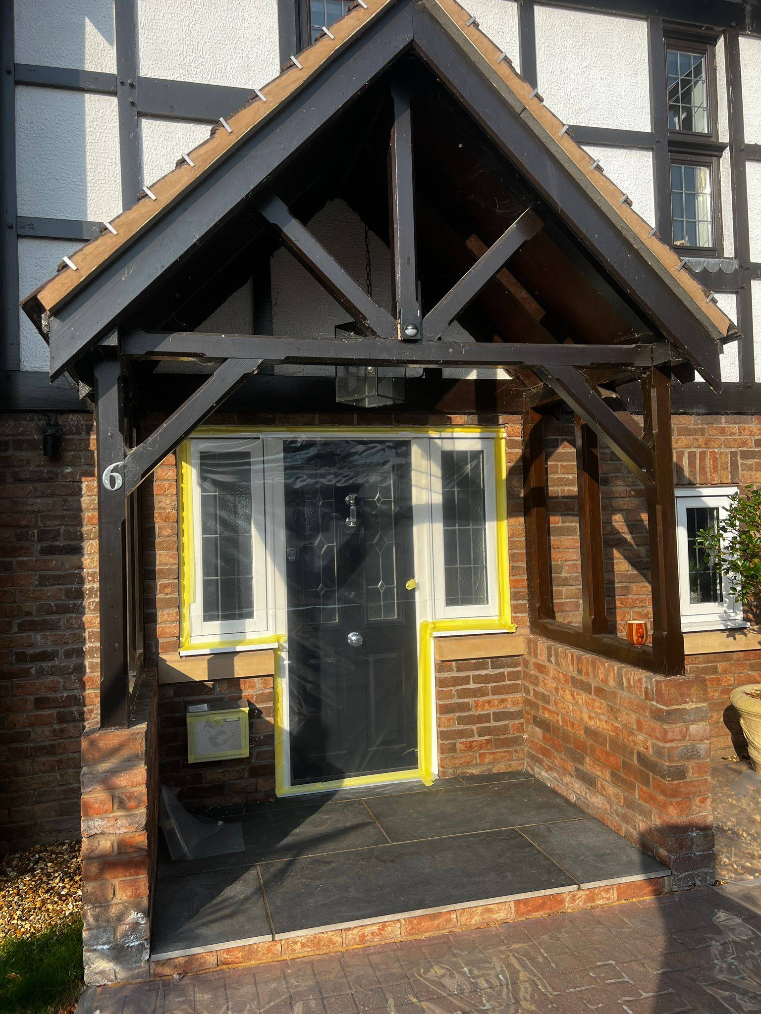 Oak porch frame before restoration showing weathered, dark and uneven exterior finish