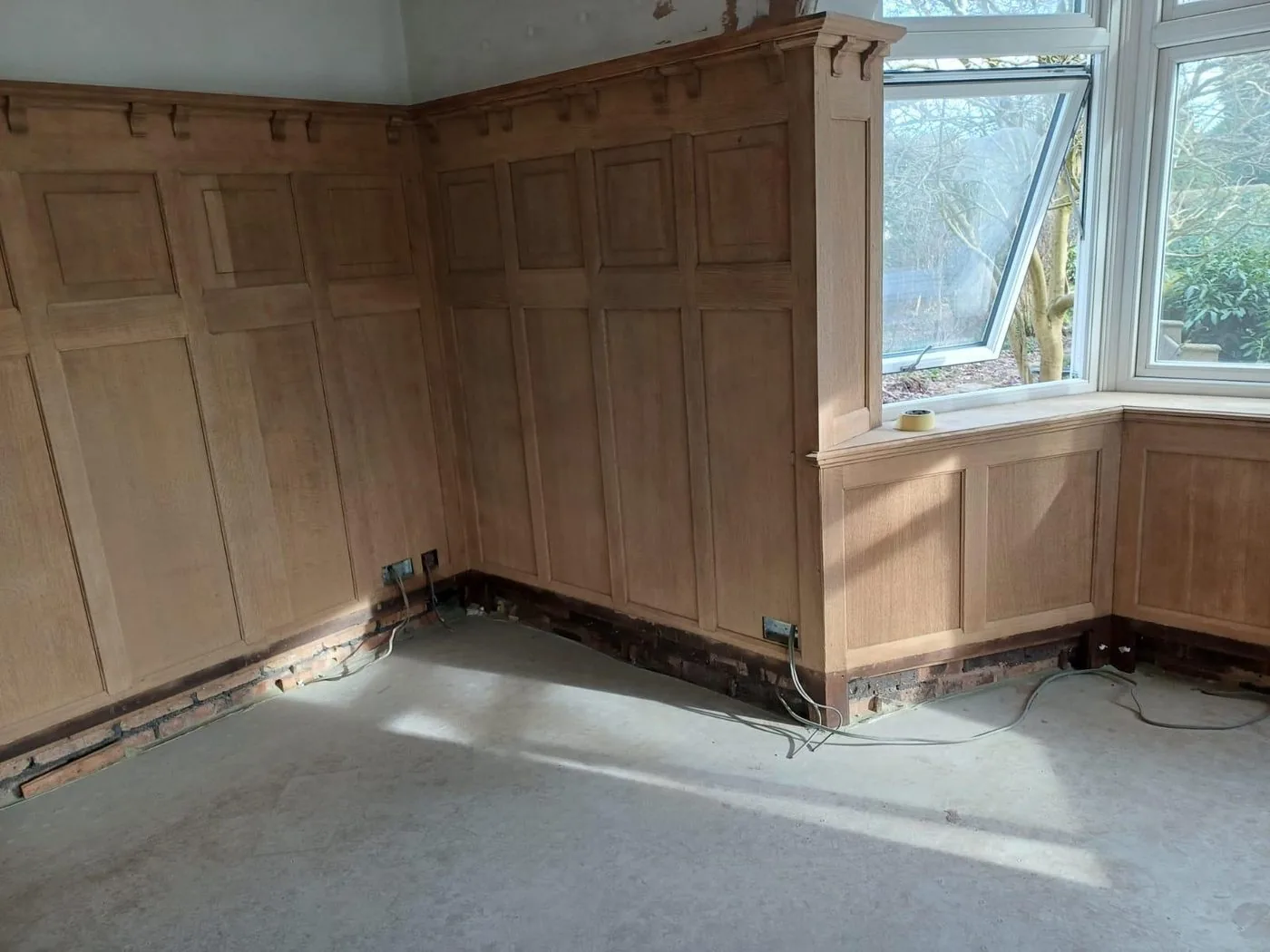 Finished period room interior with cleaned oak panels, fireplace surround and crisp decorative detailing