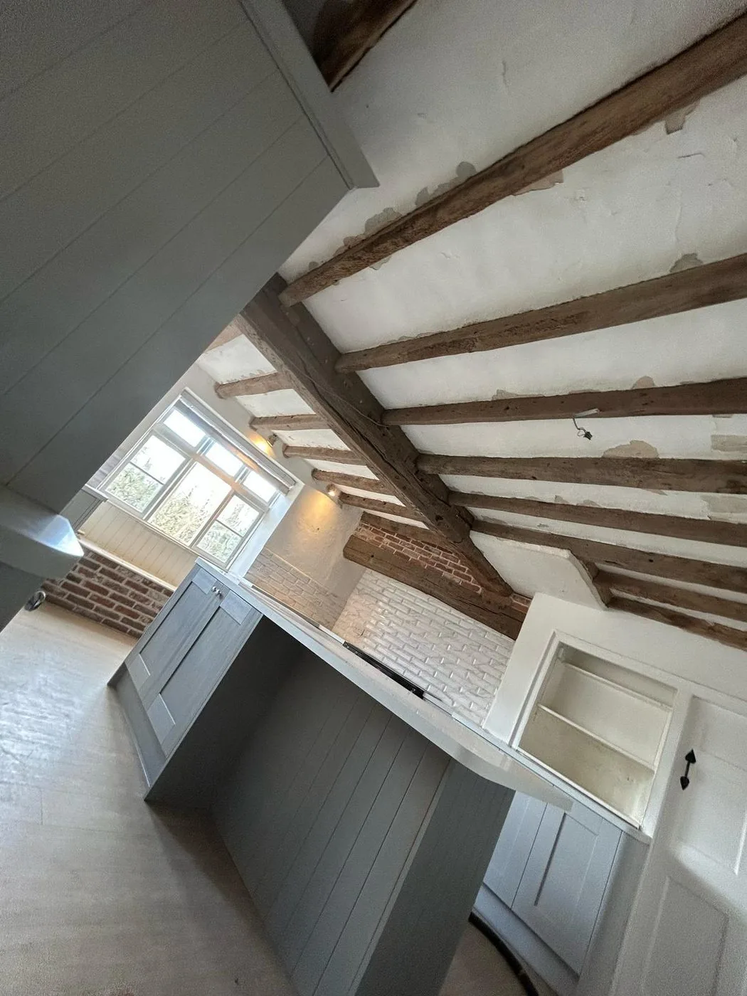 Clean, naturally toned oak ceiling beams retaining rustic texture across the cottage room