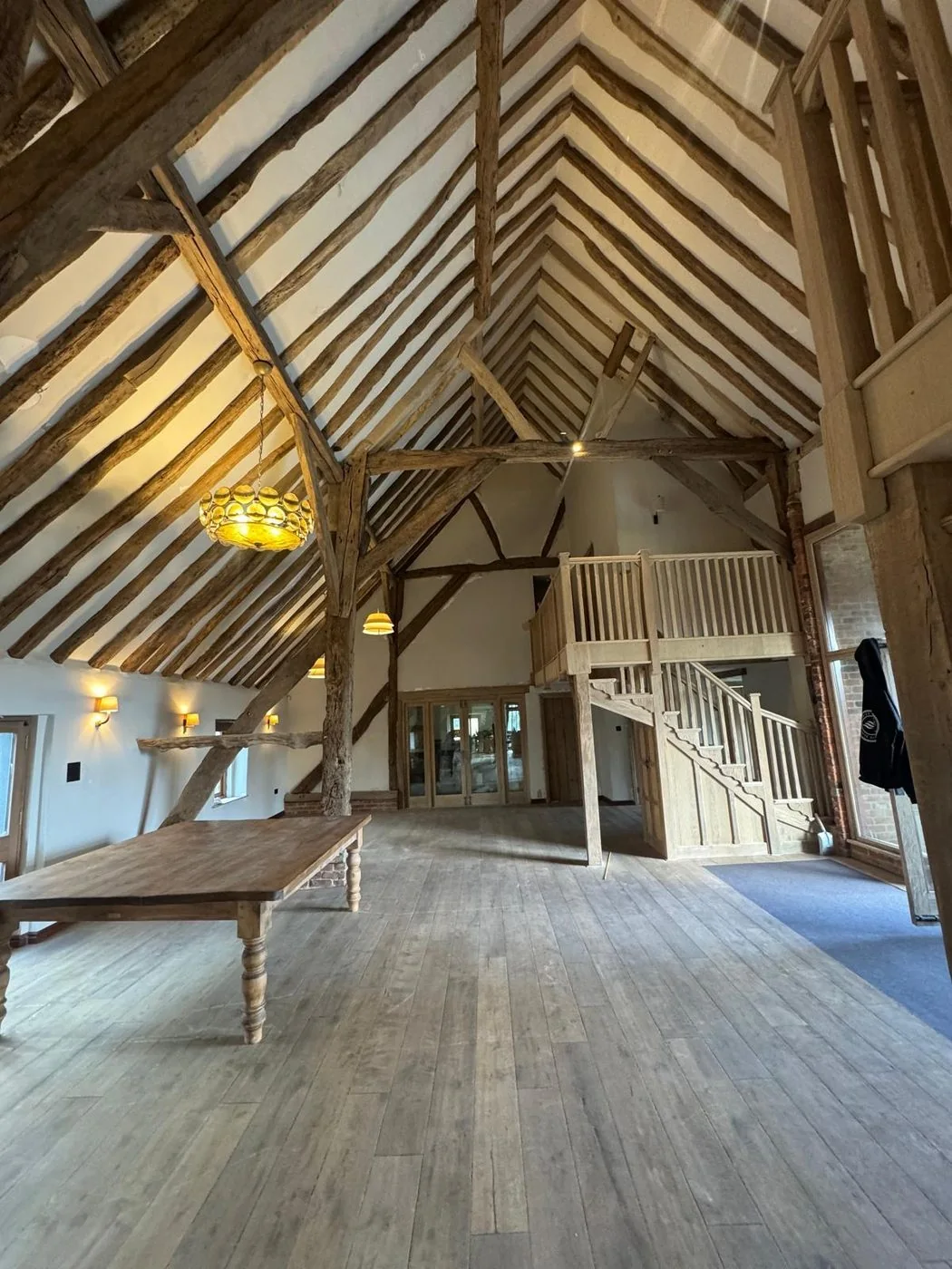 Historic barn conversion after restoration with lighter exposed oak beams