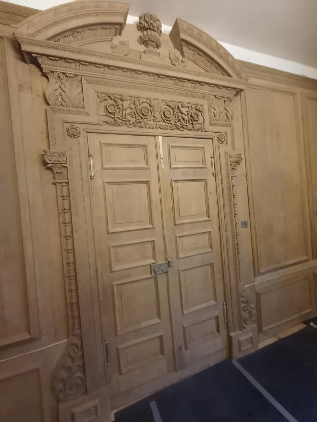 Refreshed carved fireplace surround and panelled joinery after careful coating removal