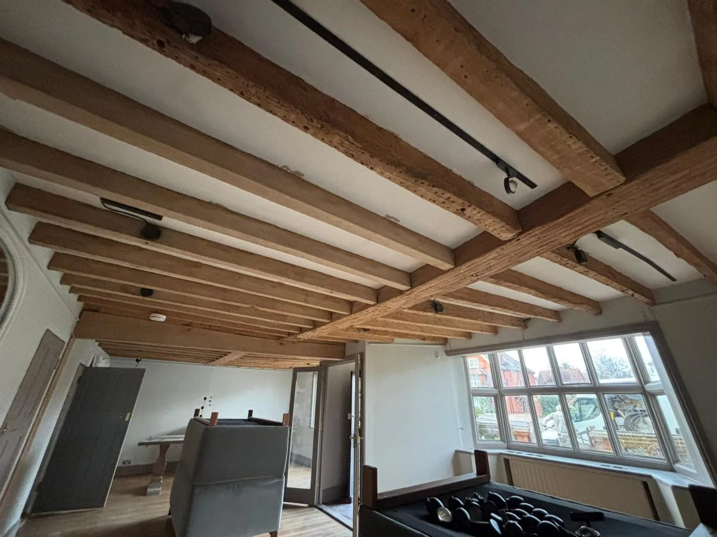 Restored oak ceiling beams with cleaner grain and lighter finish