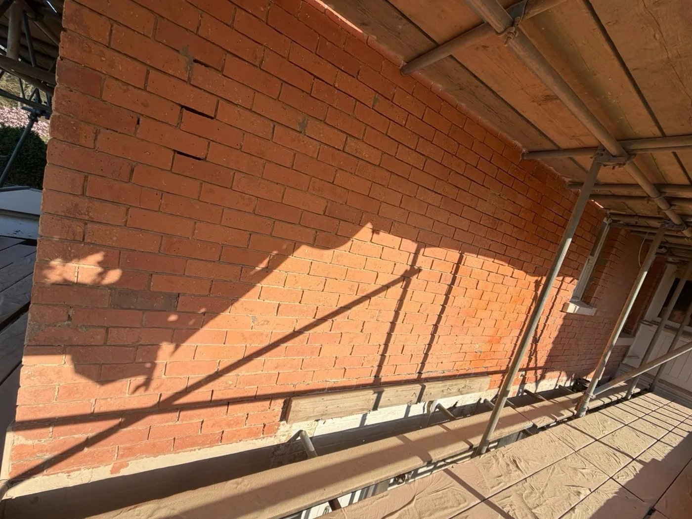 Restored brick wall showing clean natural red brick after careful paint removal