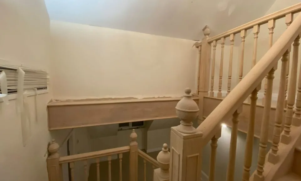 Restored oak staircase with clean handrail, turned spindles and newel posts ready for finishing