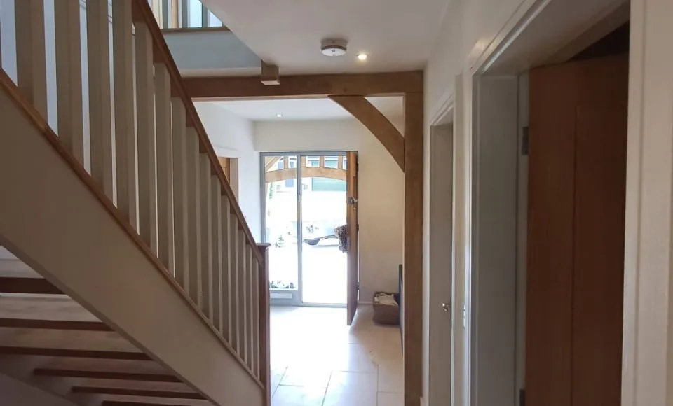 Clean restored hallway with refreshed oak beam and timber staircase details after surface preparation