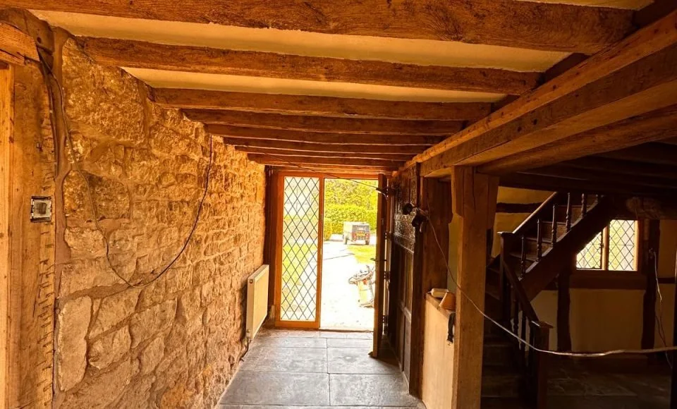 Additional restored cottage beam view showing lighter natural timber character