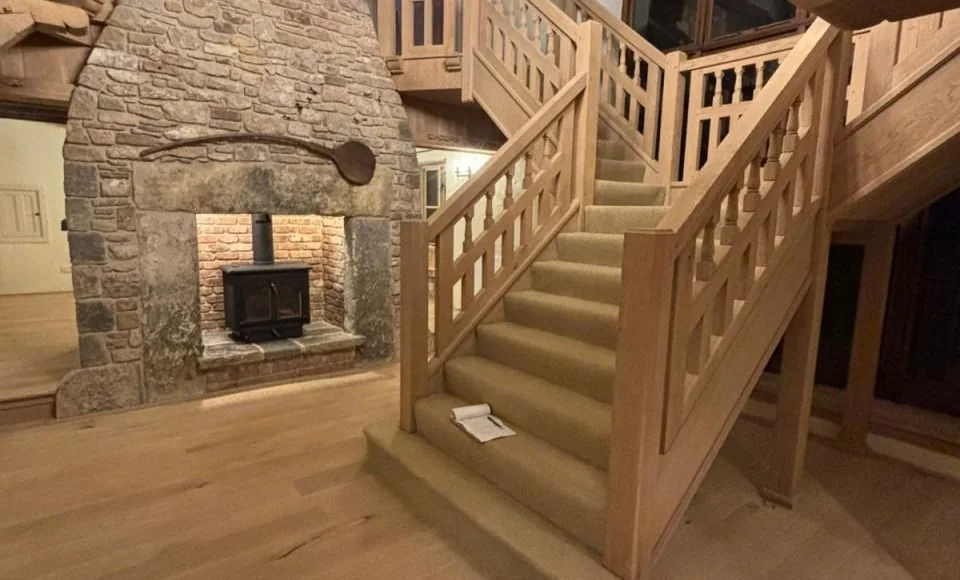 Large oak staircase and balcony framework after restoration with natural timber detail revealed