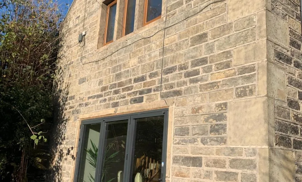 Cleaned cottage stone façade with brighter natural colour after soda blasting