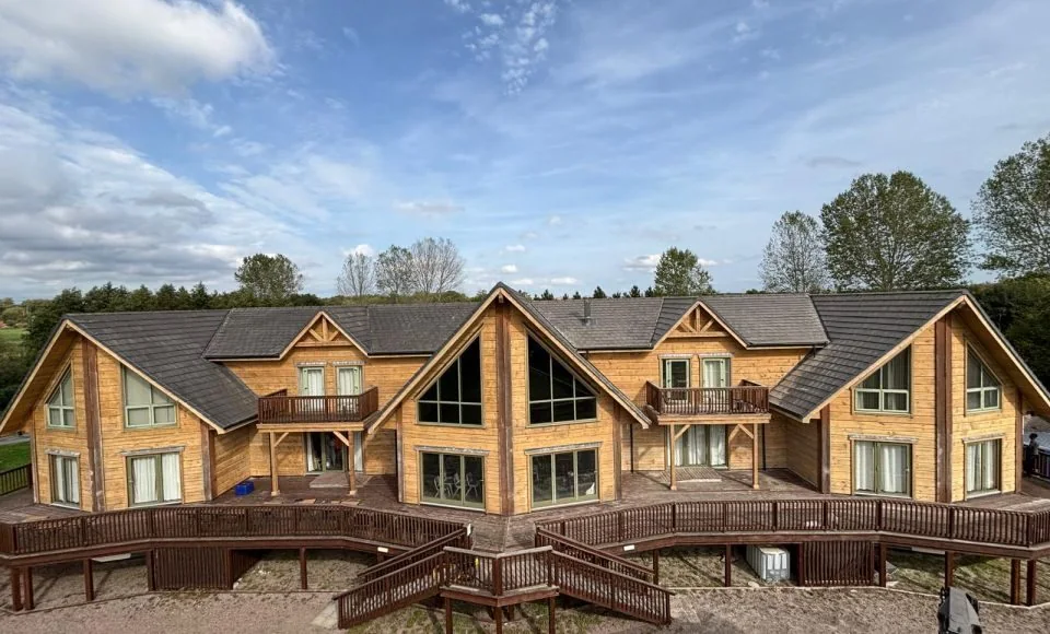 Large timber residential building after restoration with brighter natural timber façade