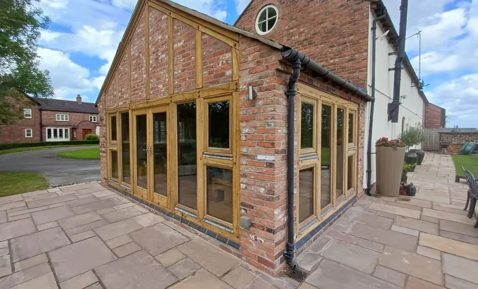Clean golden timber orangery corner and glazed side elevation after gentle soda blasting