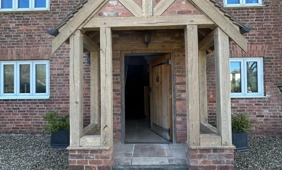 Clean restored porch doorway with natural timber frame and stone threshold