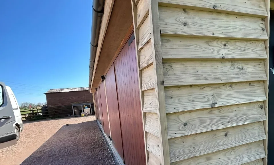 Refreshed exterior outbuilding showing restored surface condition and improved presentation after paint removal