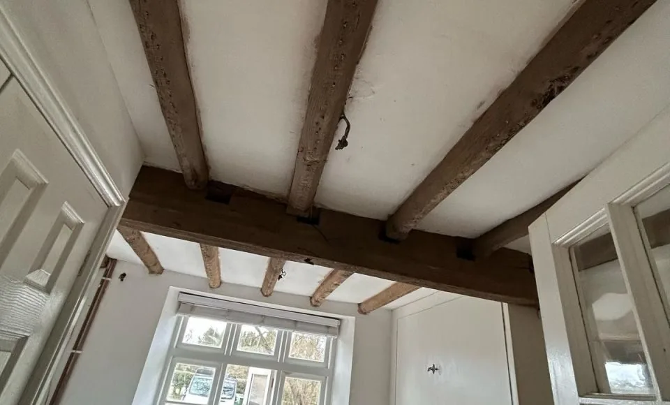 Clean natural oak beam structure after dark coating and surface grime were removed