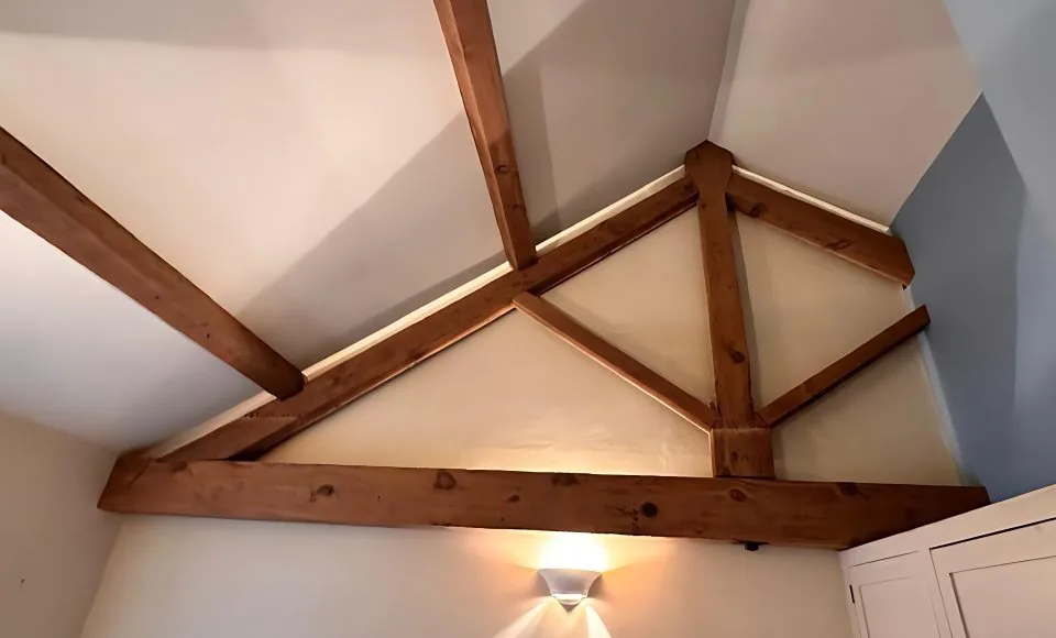 Cleaned upstairs A-frame timber showing brighter grain after careful restoration