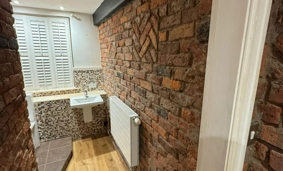 Warm exposed Victorian bathroom brickwork with restored diamond pattern detail