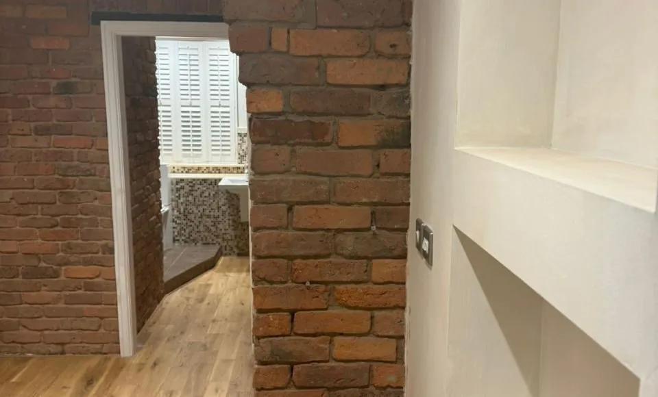 Warm natural brick wall revealed after controlled coating removal and cleaning