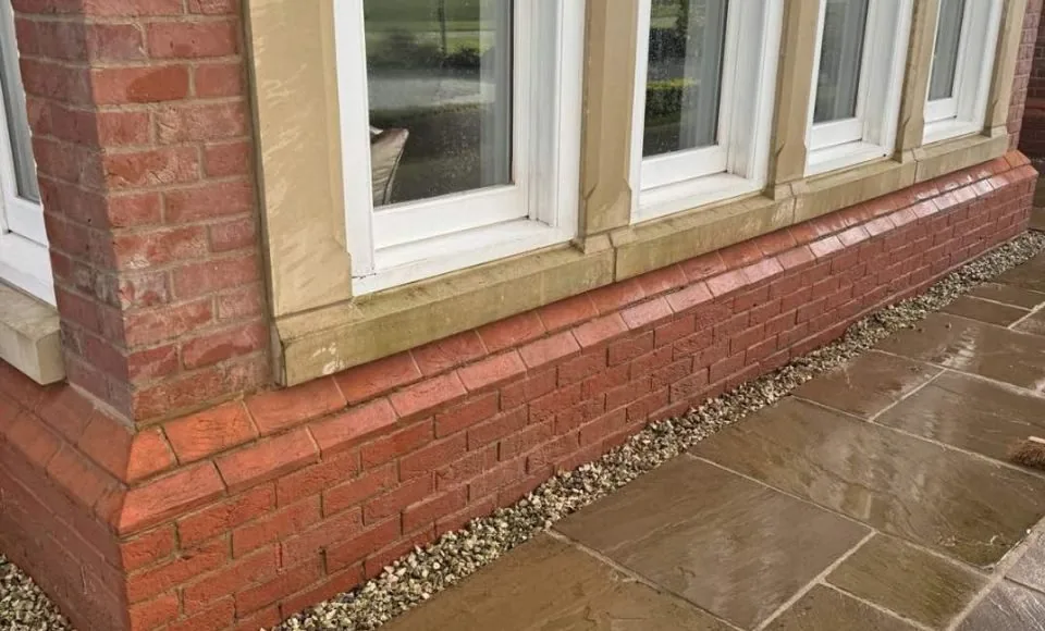 Clean bay window brickwork showing warmer terracotta tones and refreshed stone detailing after restoration