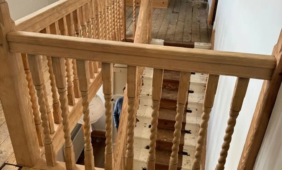Restored Victorian balustrade close view with natural timber grain and intricate decorative profiles visible