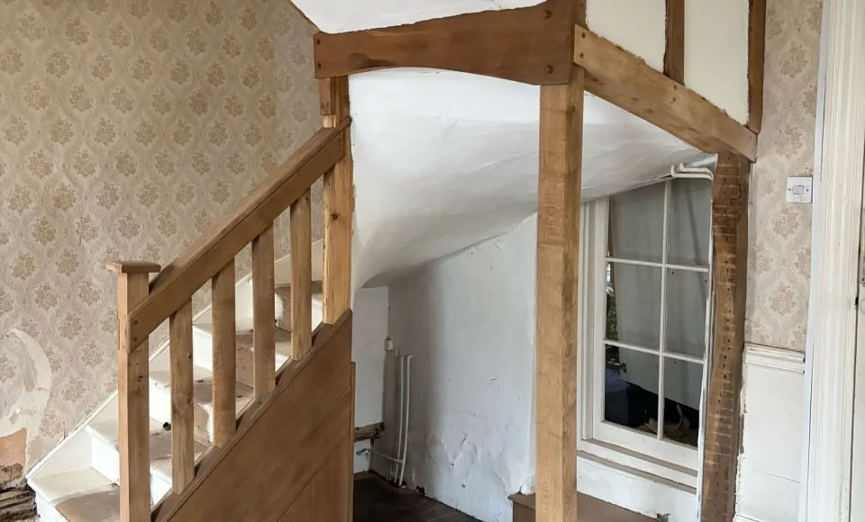 Natural honey-toned oak beams after controlled finish removal