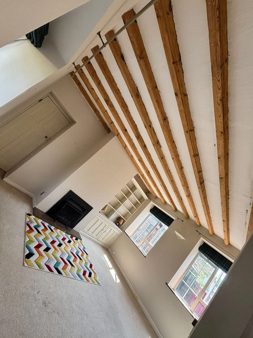Restored Cotswold stone fireplace with oak mantel and beam clearly defined