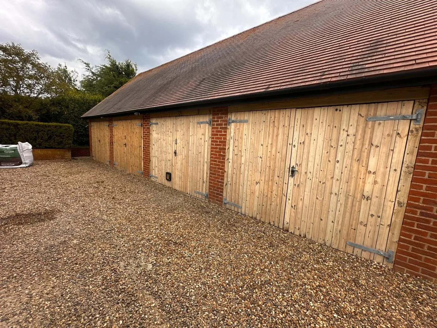 Aged patio slabs cleaned to reveal warmer tones beside the refreshed rural outbuildings