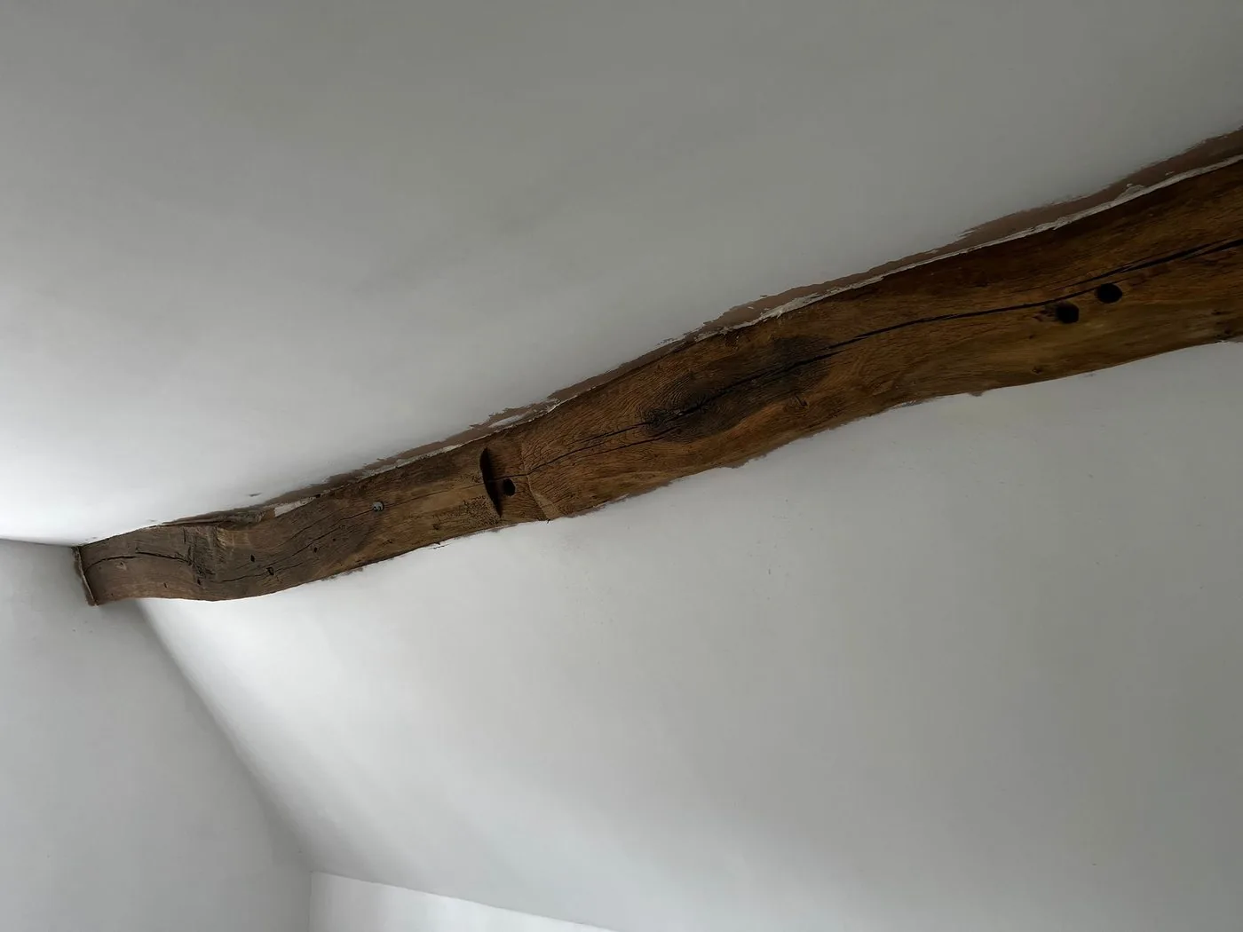 Restored oak ceiling beams with paint removed and natural timber grain revealed