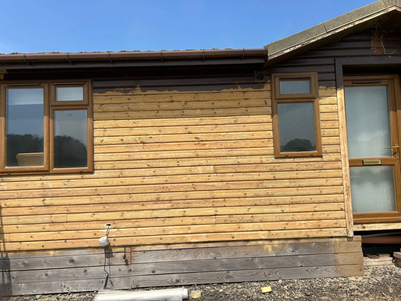 Restored log cabin exterior showing brighter clean timber, visible grain and warm natural tones