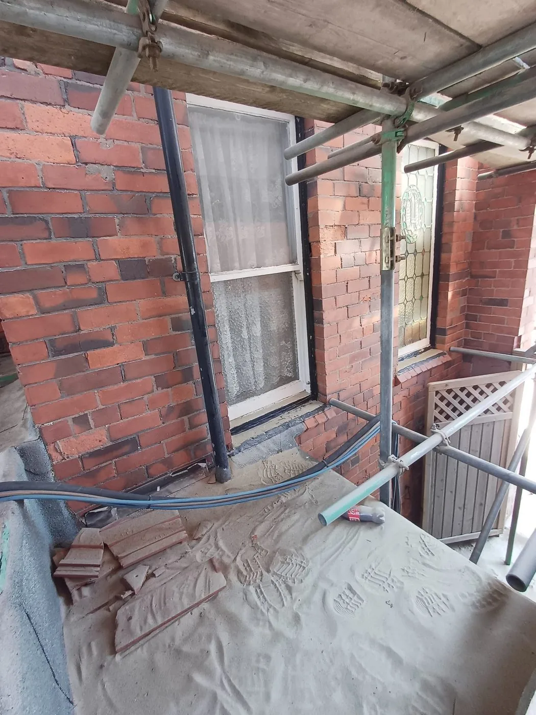 Cleaned Victorian red brick facade with brighter masonry and preserved period window detailing after restoration