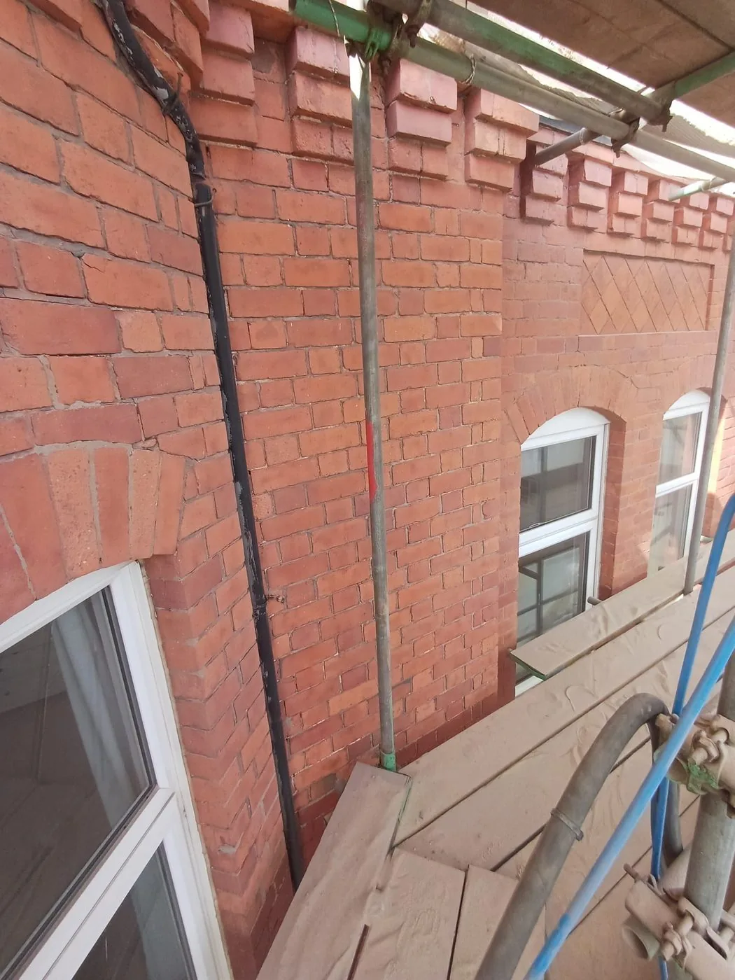 Evenly restored red brick wall showing renewed texture and clean surrounds around original sash windows