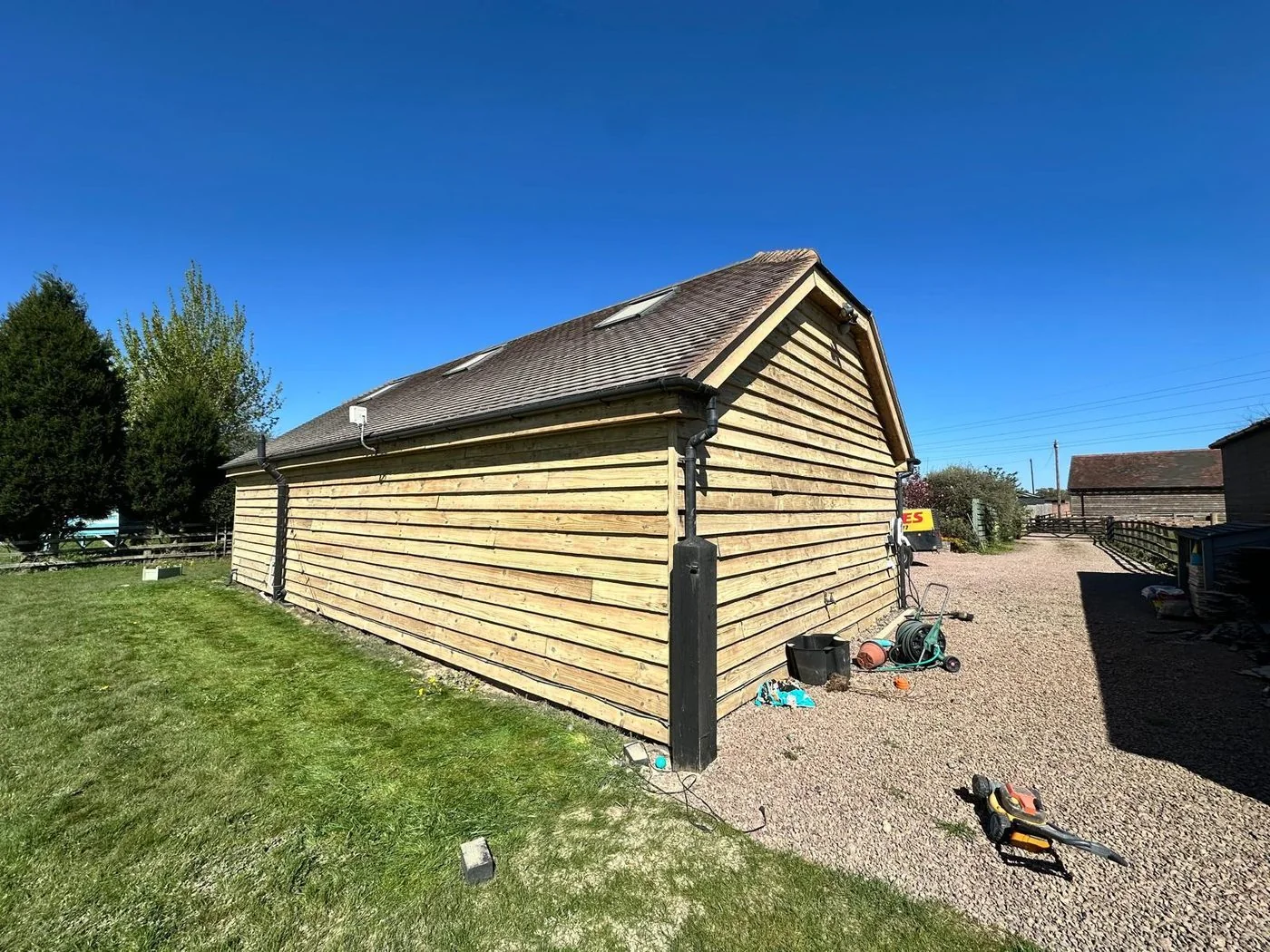 Traditional timber-clad barn after restoration with honey-toned natural wood cladding