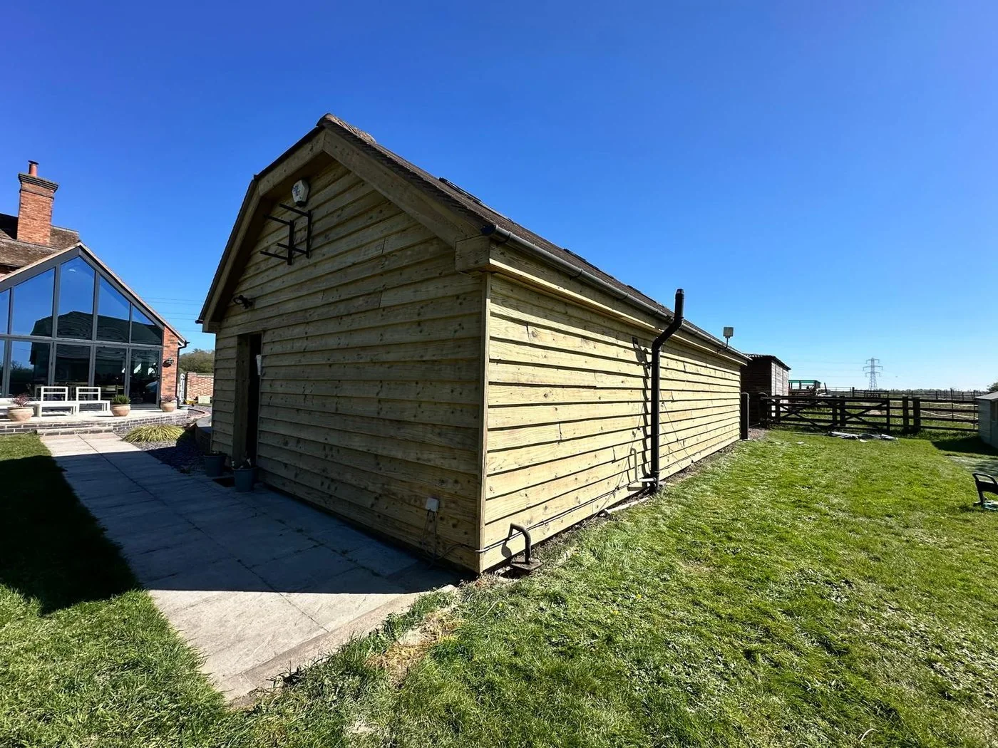 Additional restored view of traditional barn timber cladding and retained garage doors