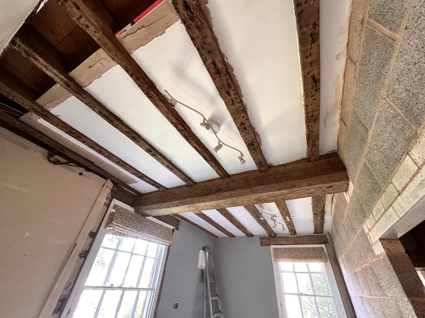 Historic oak ceiling beams after restoration with natural warmth and moulded detail revealed