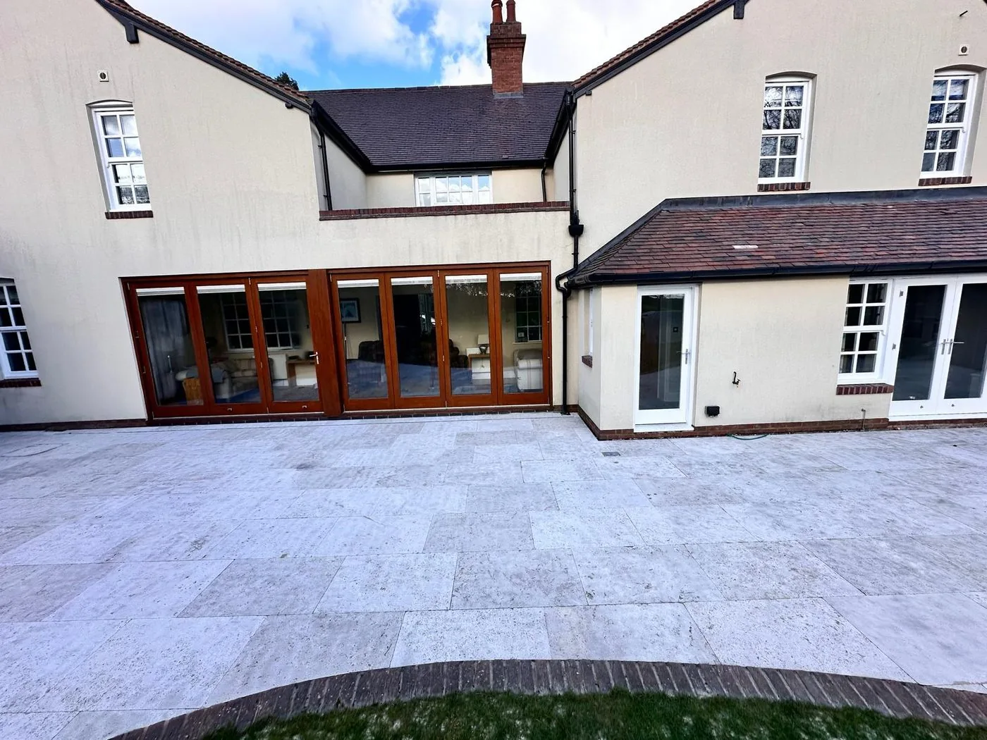 Restored limestone patio after gentle cleaning, with brighter pale stone and greatly reduced organic staining.