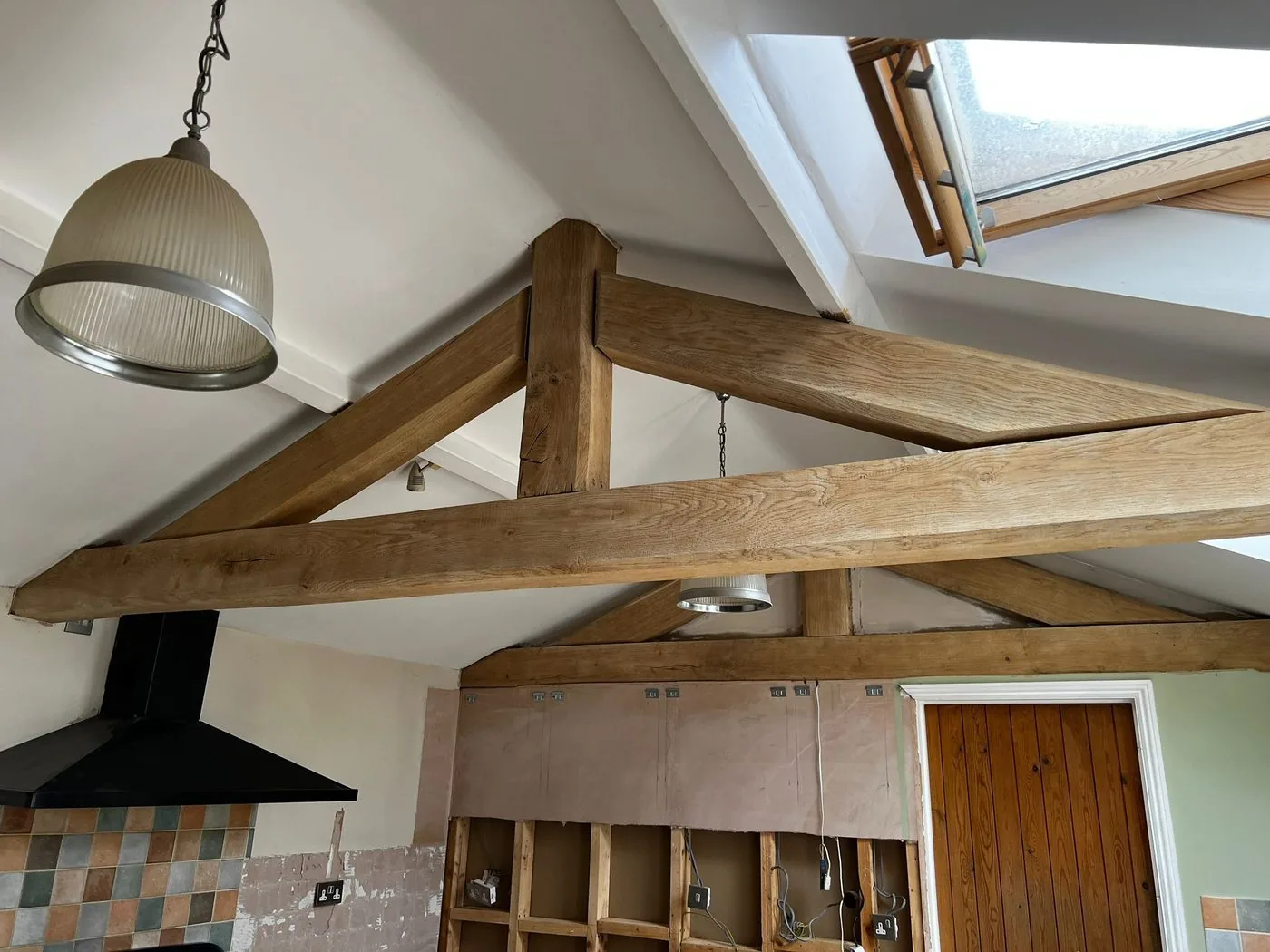 Cleaned natural oak A-frame beams brightening the finished vaulted kitchen