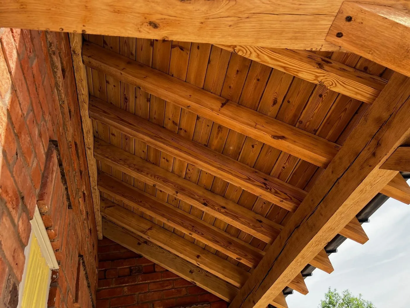 Clean tongue-and-groove oak porch ceiling and timber frame after surface restoration