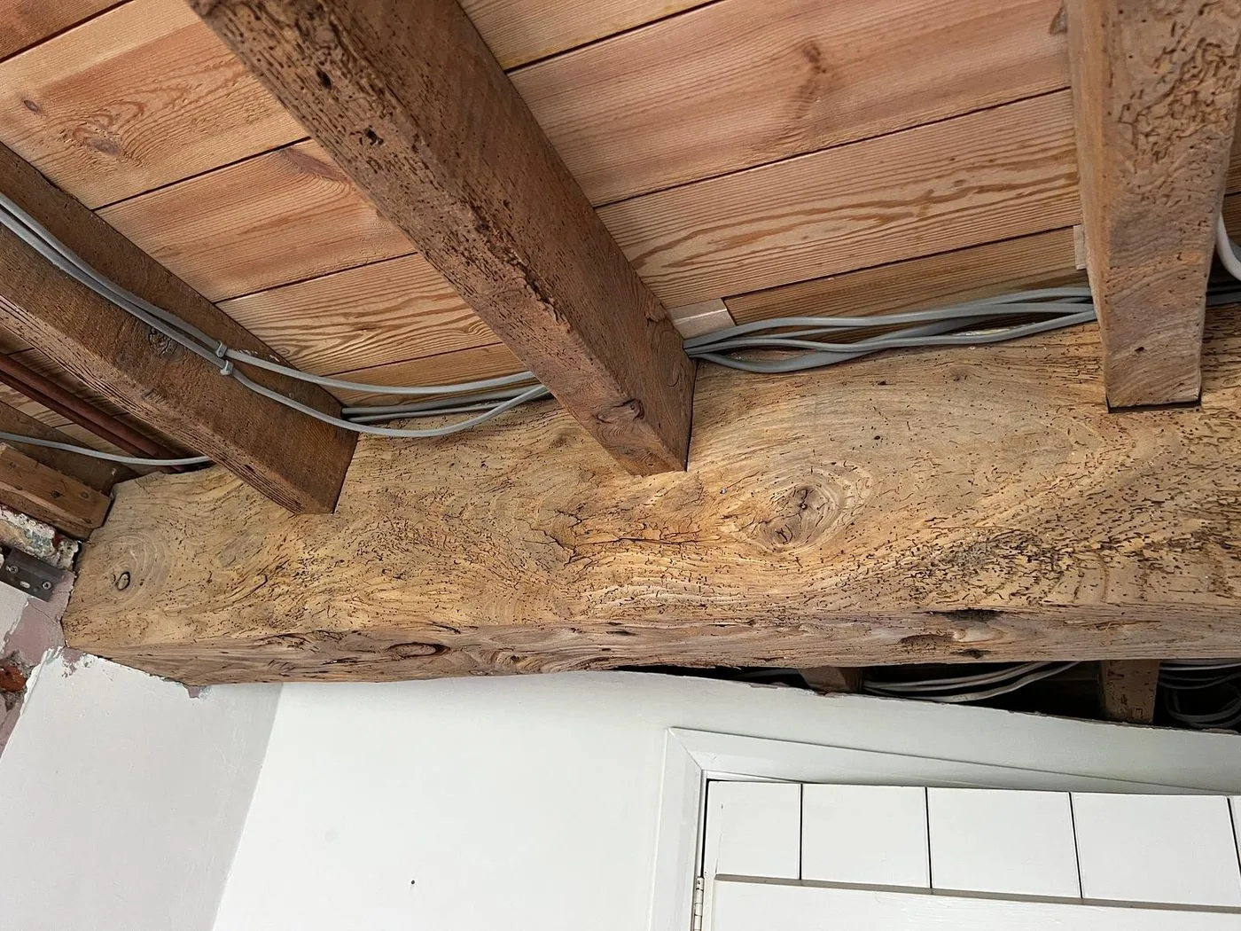 Restored oak ceiling beams with clean natural grain after gentle paint removal