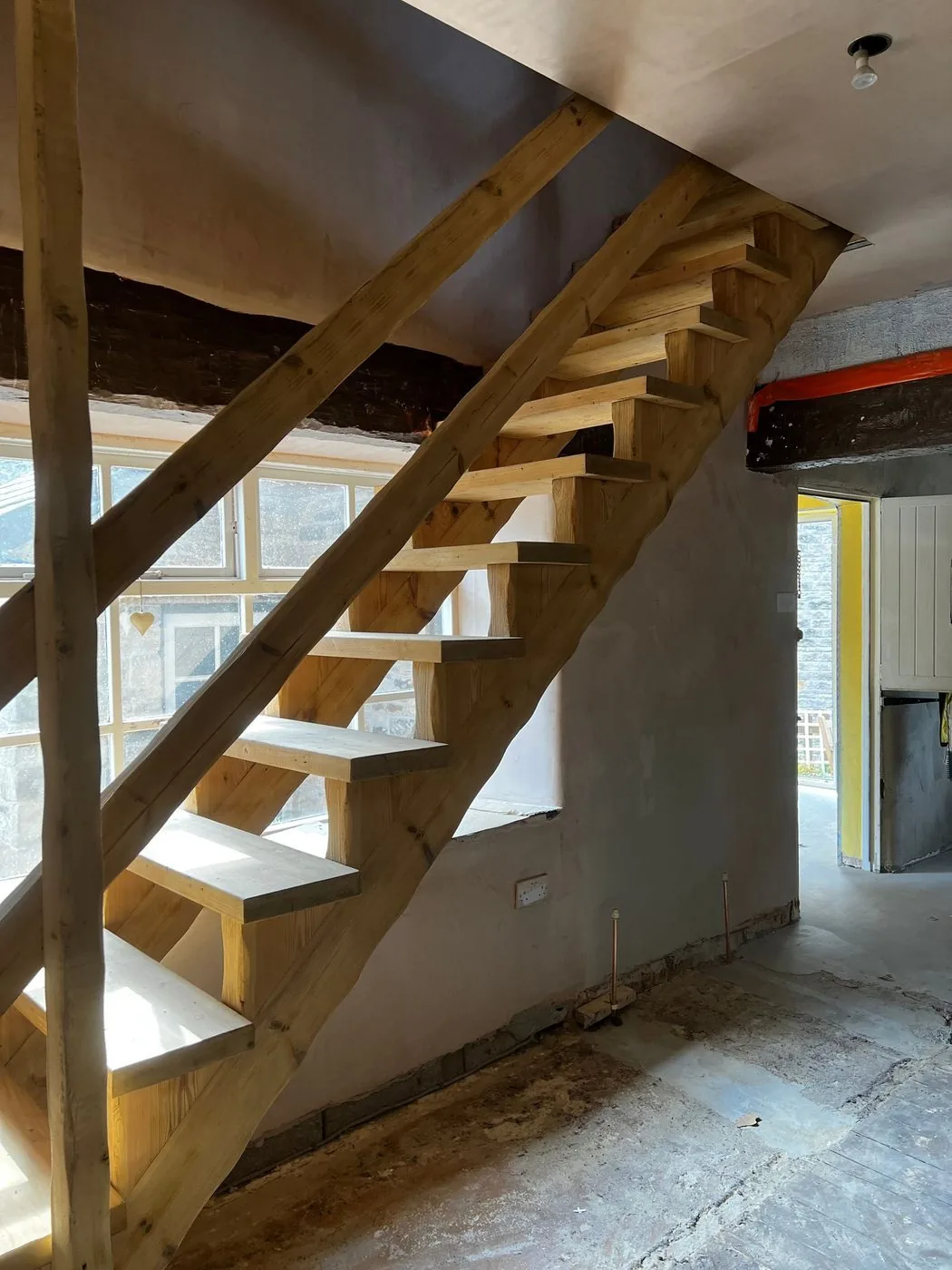 Restored timber staircase with black coating removed and natural tread grain revealed