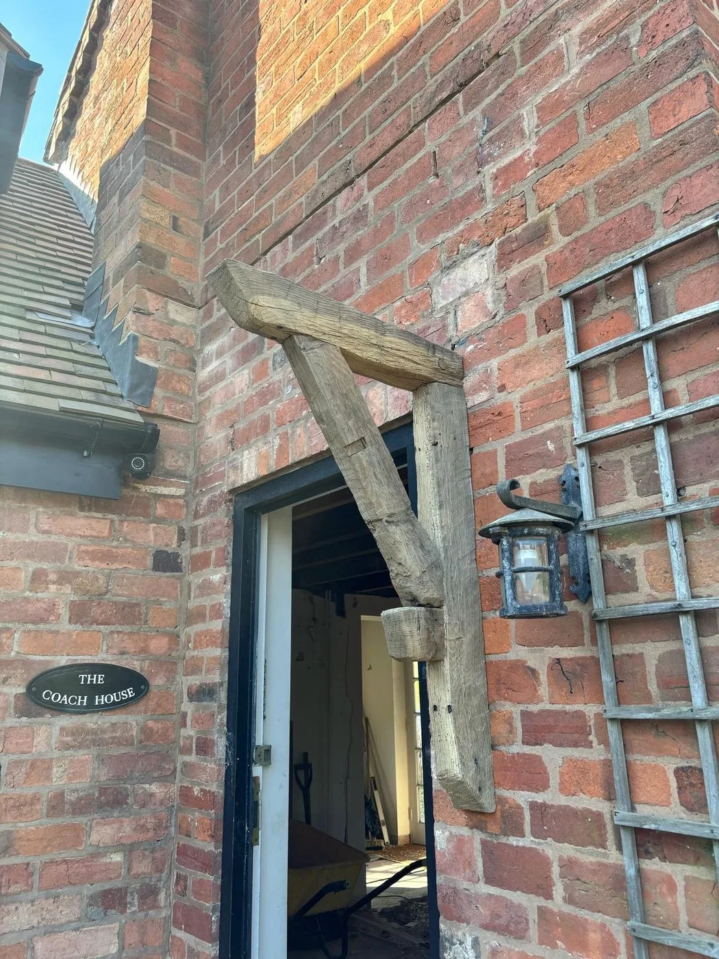 Freshly restored oak timber with natural grain revealed across the coach house interior