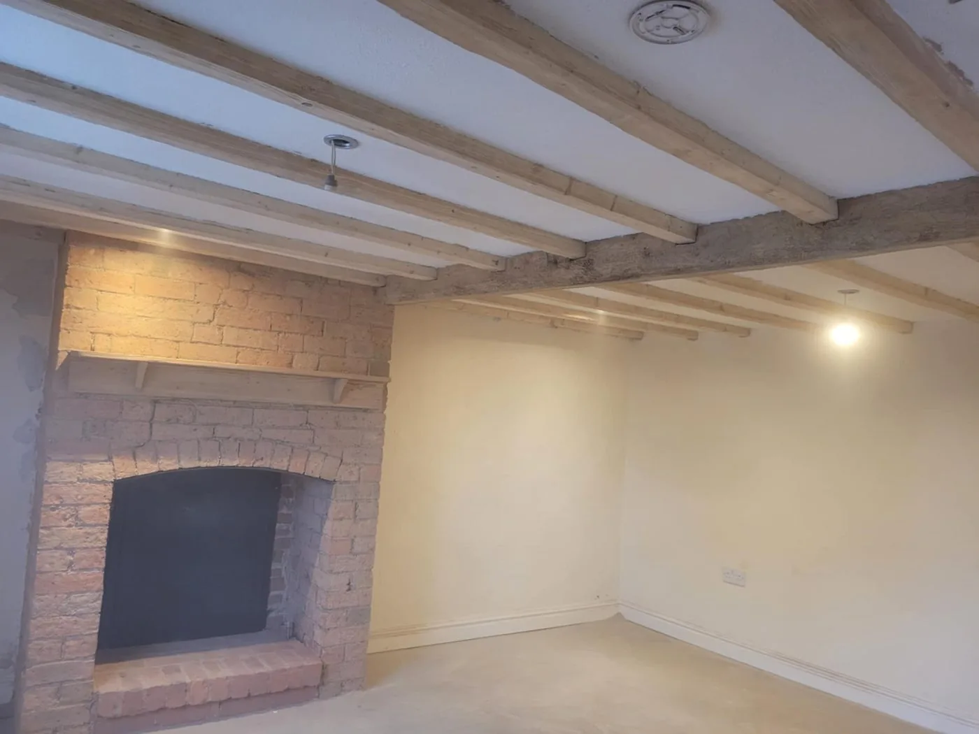 Clean honey-toned oak beams framing a bright restored living space