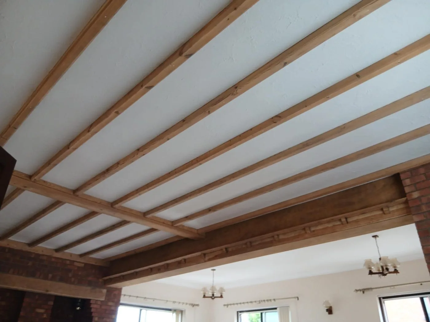 Restored ceiling beams with cleaner natural timber grain brightening the kitchen