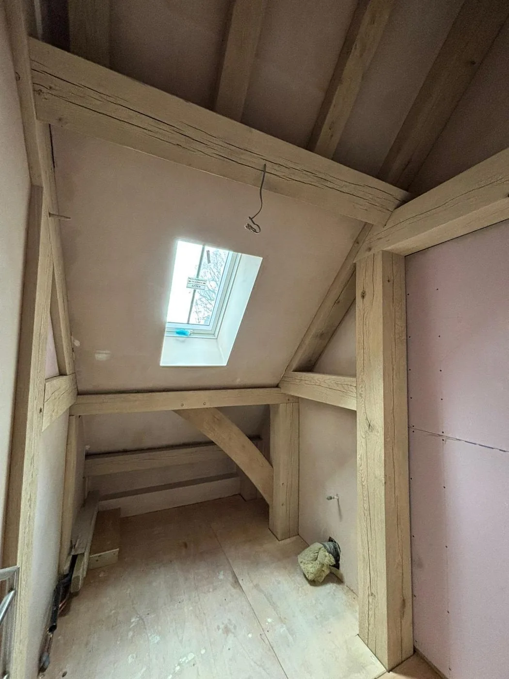 Finished oak structural beams looking even and warm beneath the barn conversion vaulted ceiling
