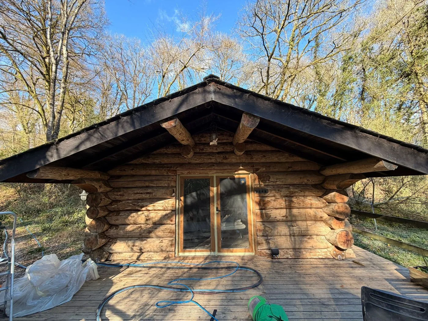 Restored log cabin wall showing cleaner timber, brighter natural colour and preserved rustic texture