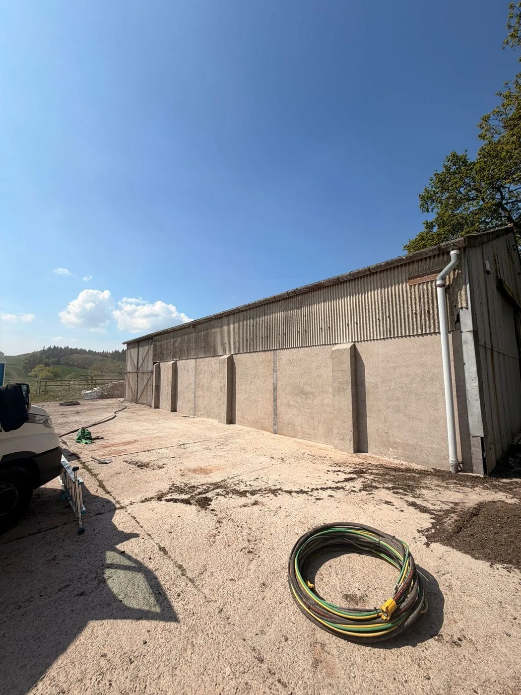 Cleaned profiled metal barn roof and lower wall panels showing an even restored agricultural exterior