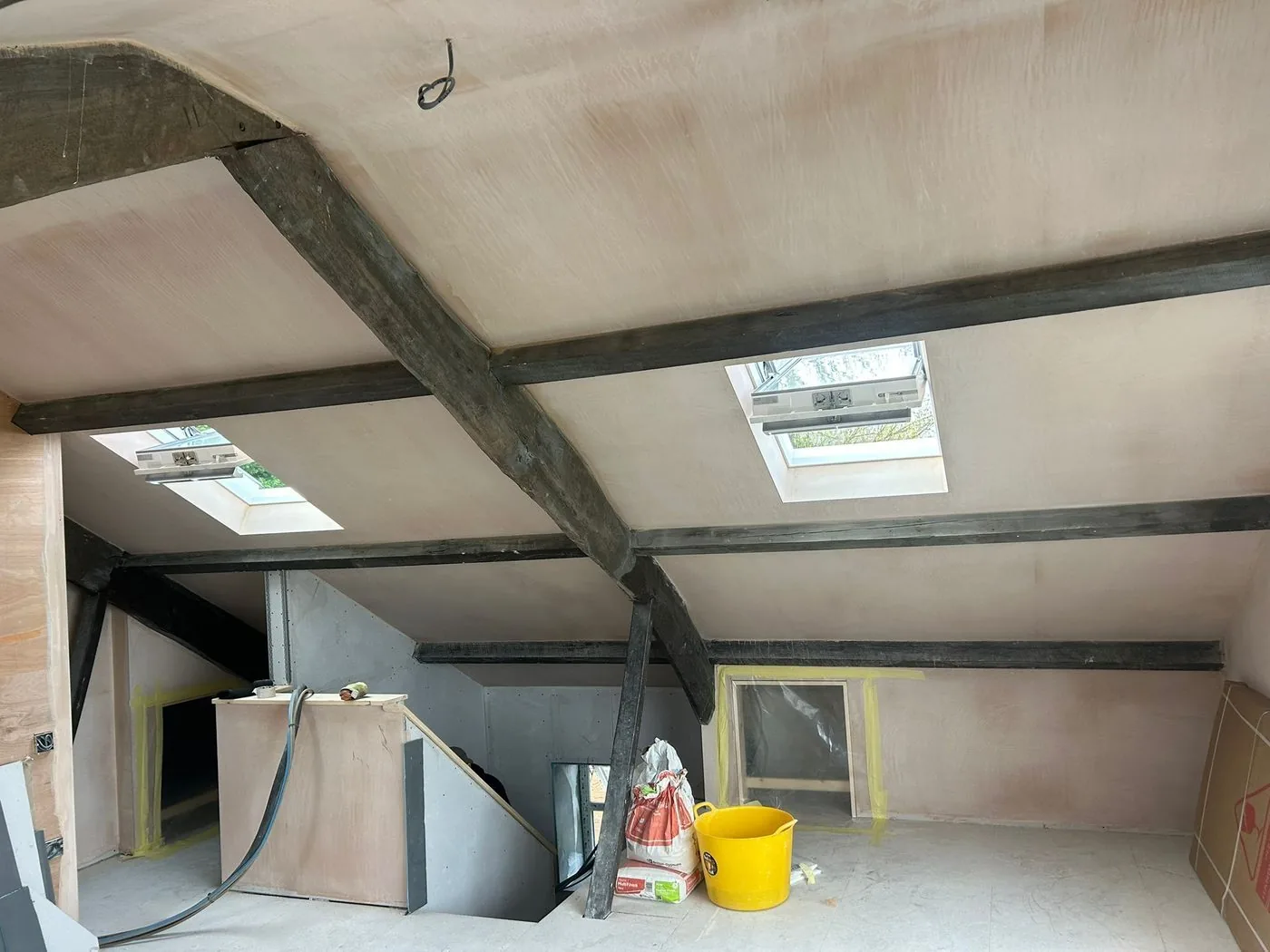 Dark weathered coating covering exposed oak beams in a period loft conversion