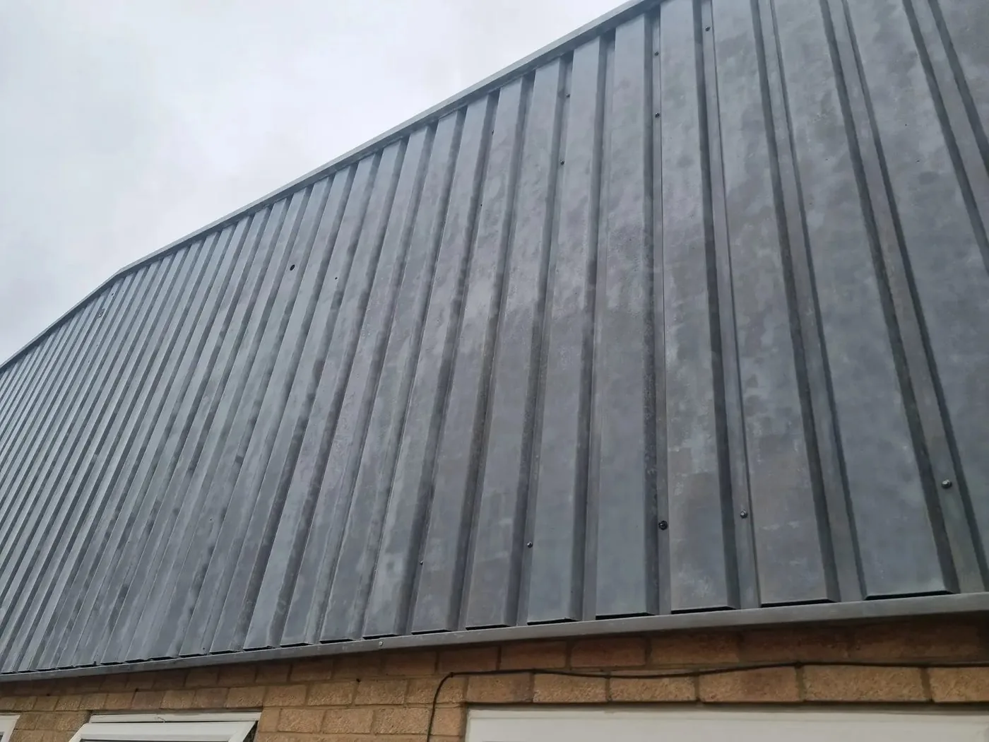 Factory cladding after controlled coating removal with a clean, even metal surface ready for recoating