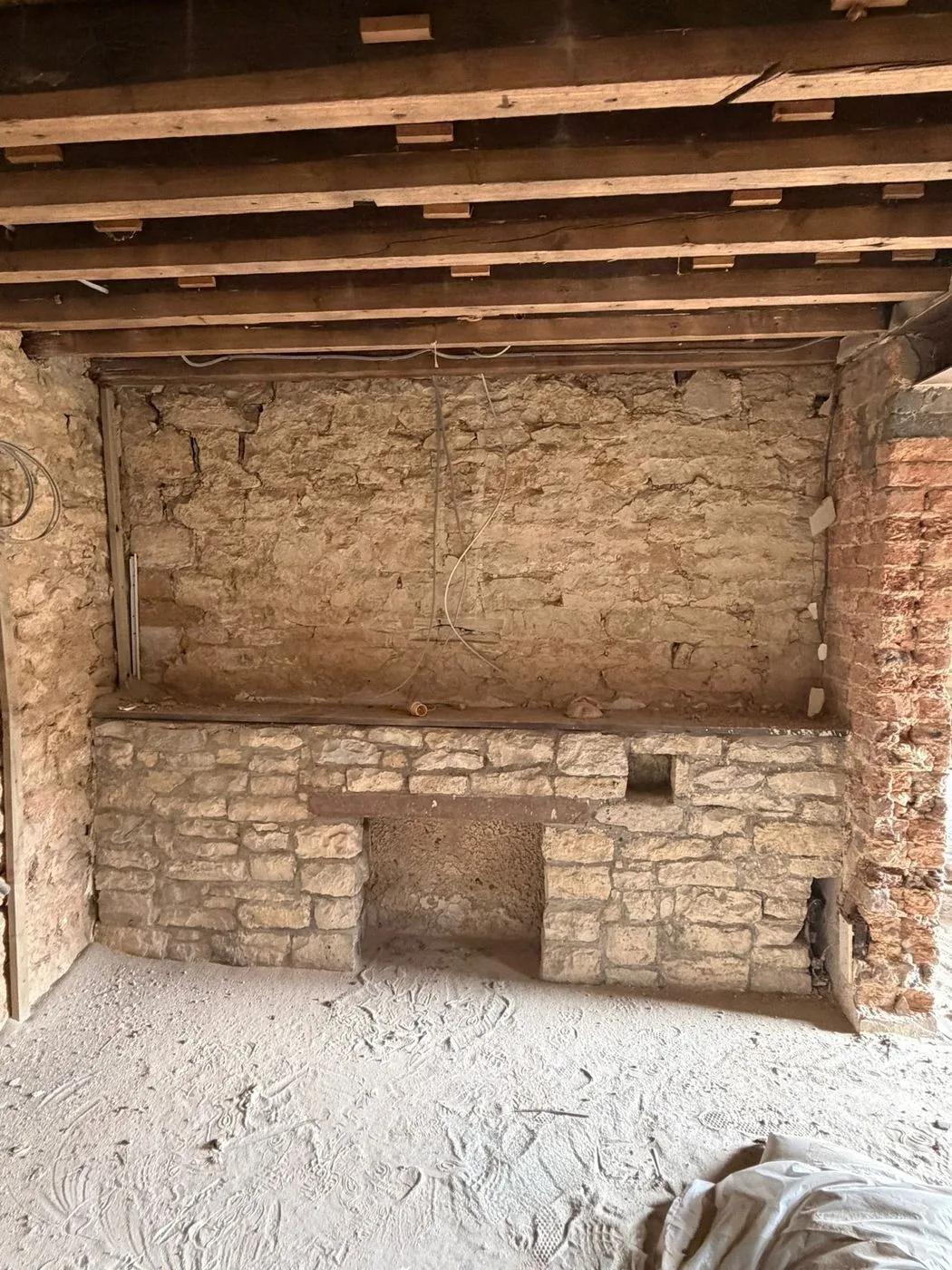 Cleaned inglenook stone fireplace showing restored colour and natural texture