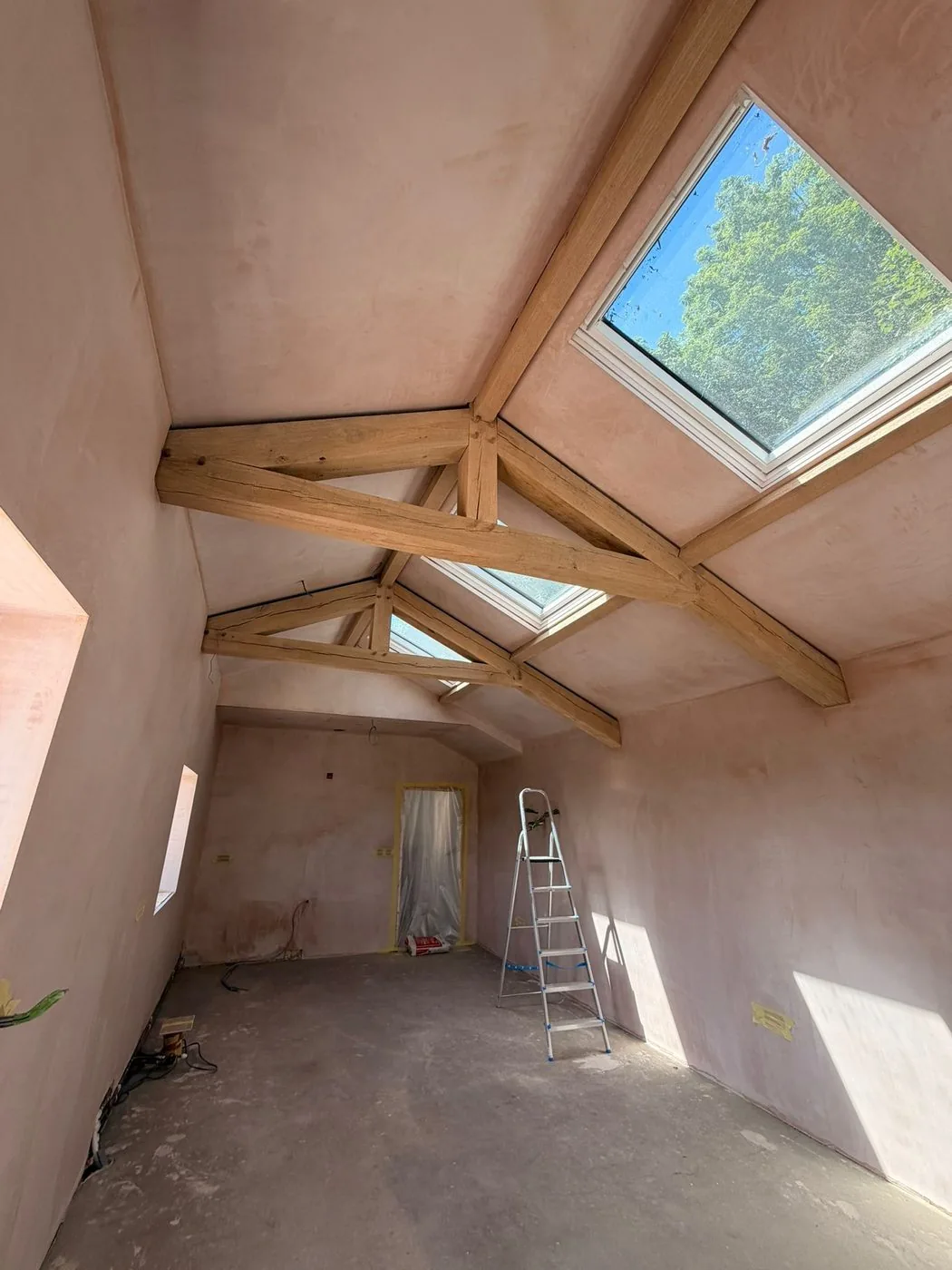 Clean restored oak A-frame roof beams showing an even natural timber grain and brighter vaulted ceiling finish after gentle surface treatment