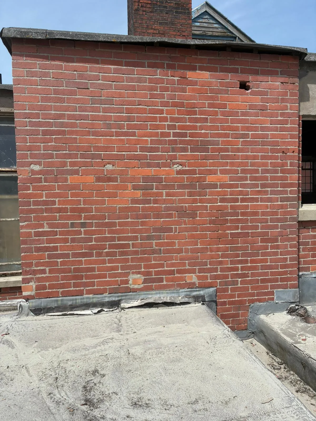 Retail brick wall after graffiti removal with cleaner original masonry revealed
