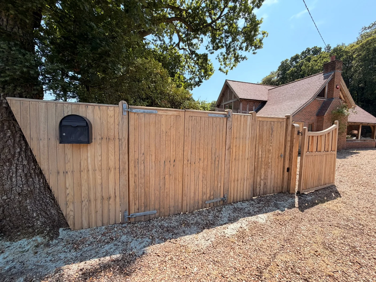 Large wooden estate gates after restoration with clean bare timber ready for treatment