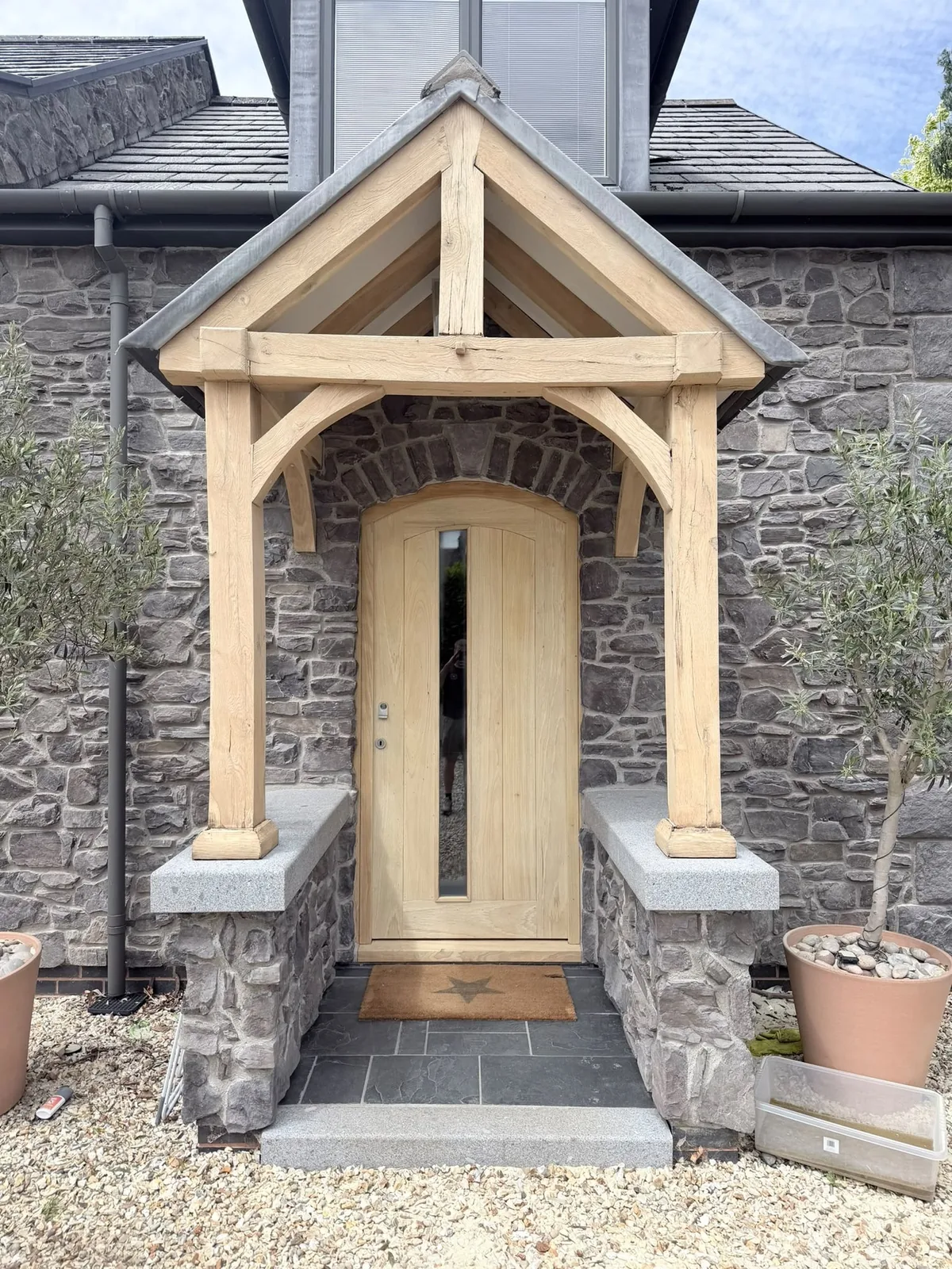 Restored oak porch, outbuilding and gates with a brighter natural grain and refreshed surrounding stonework